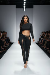 Woman wearing a black outfit with lace-up details on a white background